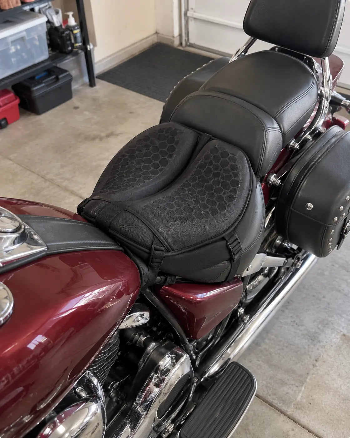 Black gel motorcycle cushion installed on a cruiser seat in a garage